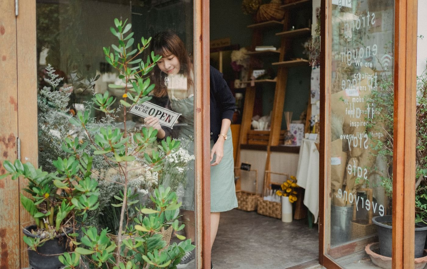 Shop owner turning the open sign at their storefront